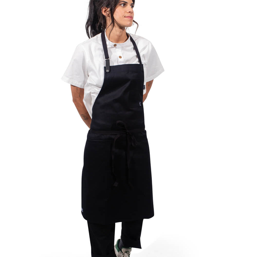 Person wearing a black apron over a white shirt on a white background
