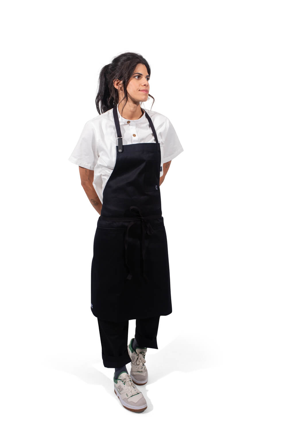 Person wearing a black apron over a white shirt on a white background