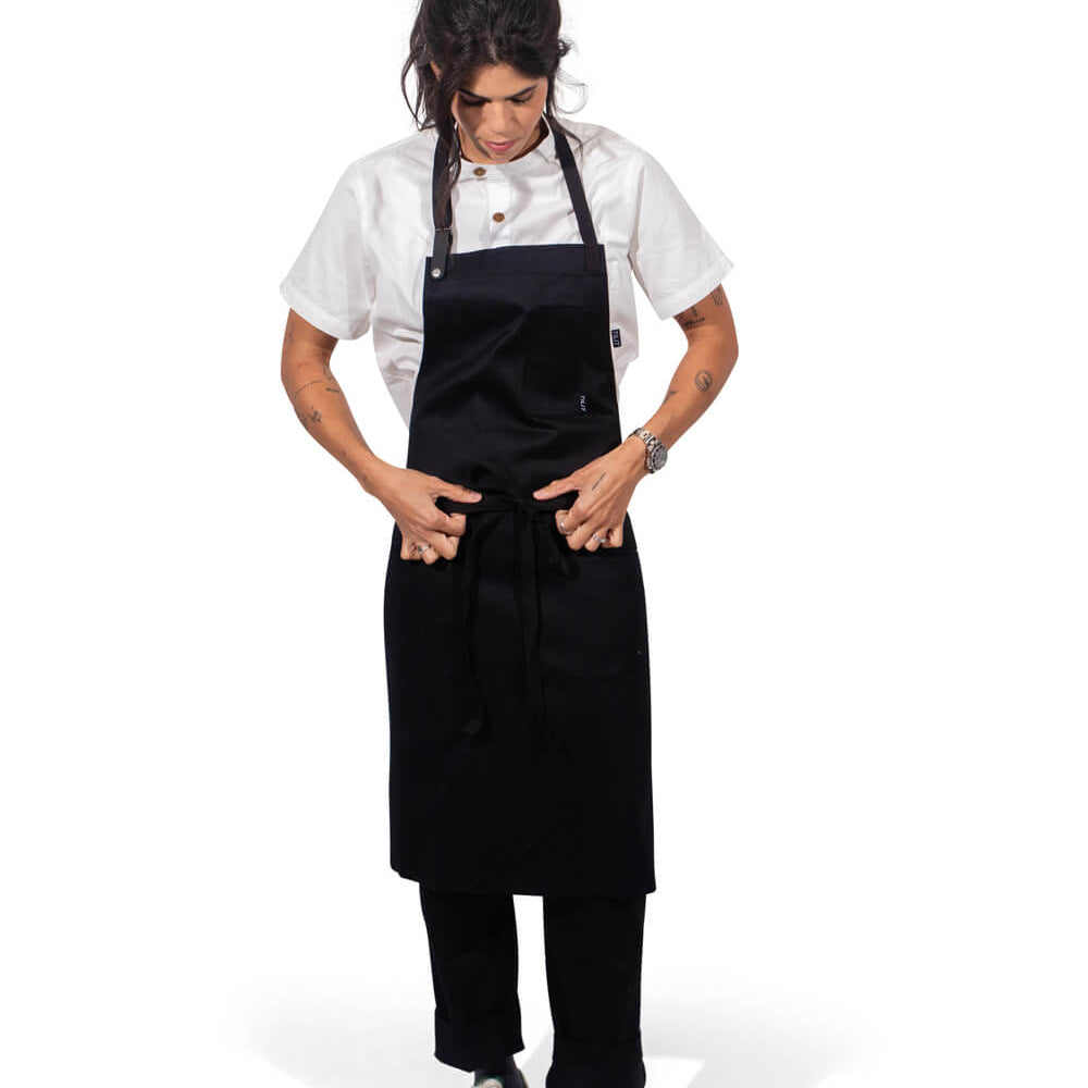 
                  
                    Person wearing a black apron over a white shirt on a white background
                  
                