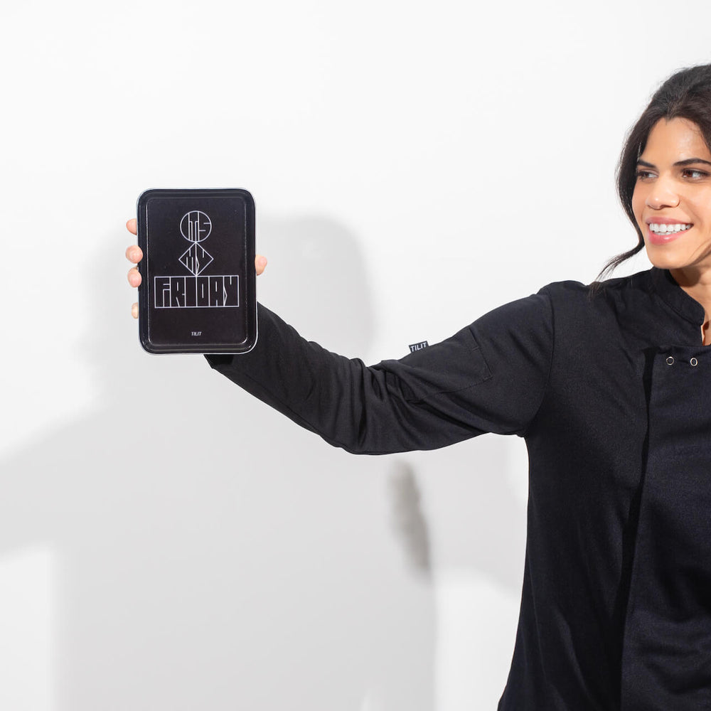 Woman holding a black rectangular cam tray with a design on a white background